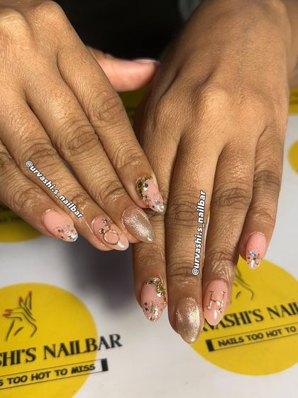 A delicate and dreamy manicure featuring a soft pink base with gold accents. I added personalized initials, a tiny ring charm, and a sprinkle of glitter for a charming and romantic feel.