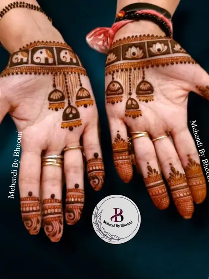 A unique design featuring hanging jhumkas (bells) and a band of elephants on the wrist. This is a great example of how I mix different traditional motifs to create something new.
