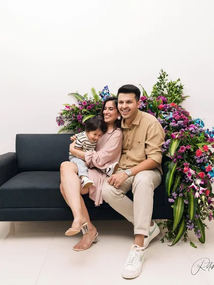 A beautiful family portrait for a first birthday, set against a stunning floral backdrop right in their home. This shows how we can create a stylish and personalized shoot in your own space.