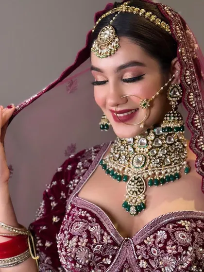 An amazing bridal look in a deep velvet lehenga, paired with a heavy kundan and emerald necklace.