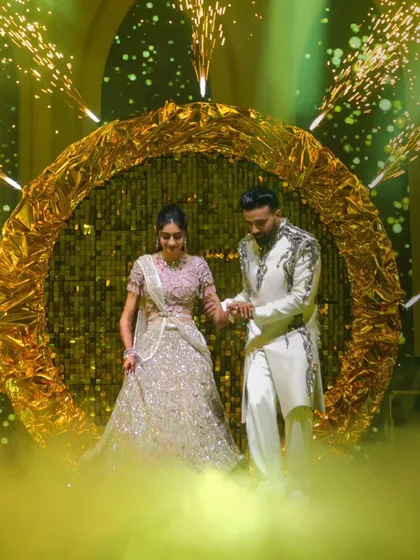 The couple's entrance should be nothing short of spectacular. I designed this shimmering golden halo with integrated pyrotechnics and a soft fog effect to make them feel like they are walking on clouds as they enter their Sangeet.