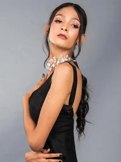 This angle showcases the low back of the dress and the model's profile. It adds a sense of grace and vulnerability, while also providing a clear view of the garment's design from a different perspective.