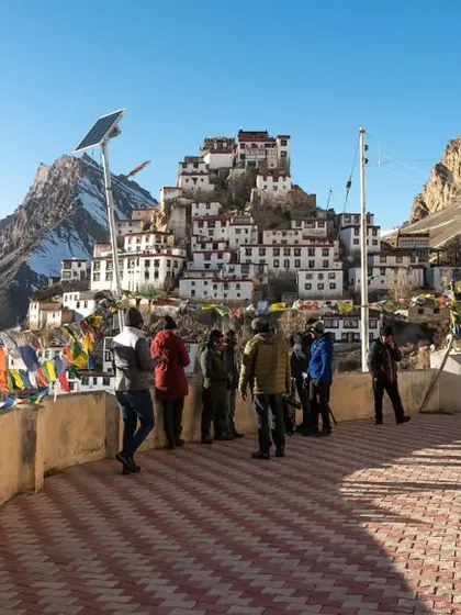 Tourists at Kee Monastery, taking in the panoramic views. This photo captures the essence of a travel experience, showing people interacting with the magnificent destination.