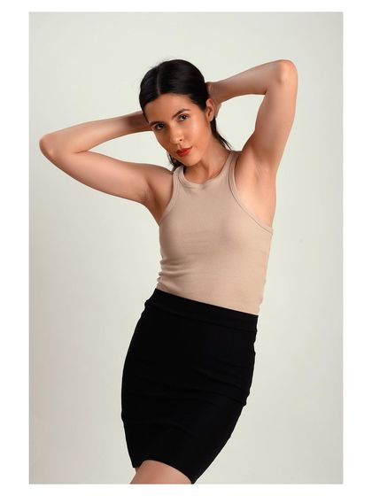 A simple and classic studio portrait. The neutral-colored top and clean background keep the focus on the model's natural beauty.
