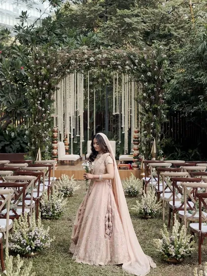 An enchanted garden wedding aisle at Taj The Trees, with the bride framed by a lush, natural archway.
