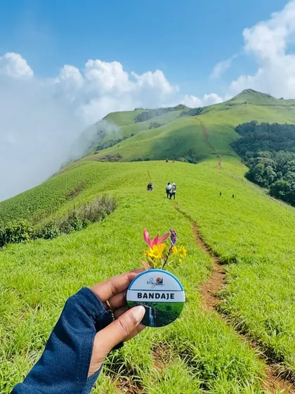 A creative shot of the Bandaje trek badge against the backdrop of the rolling green hills.