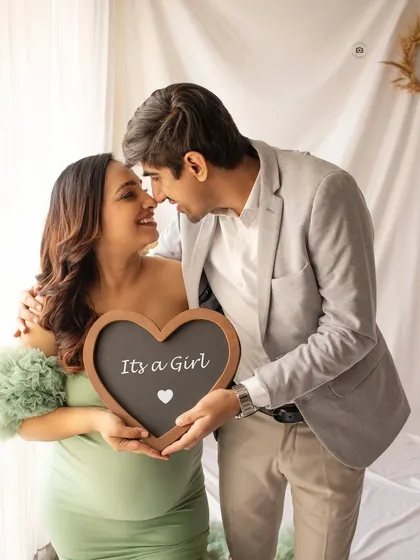 "It's a Girl!" A happy couple shares their exciting news. Using props like a chalkboard heart is a fun way to personalize your baby announcement pictures.