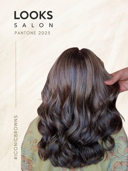 A back view of long, wavy hair with beautiful ash brown and blonde highlights. This look is part of our "Iconic Browns" collection, perfect for a sophisticated and modern style.