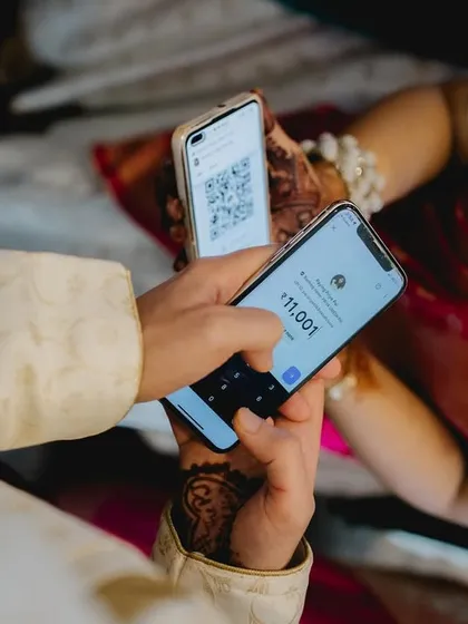 The negotiation begins! After successfully hiding the shoes, the groom makes a digital payment to get them back. A modern twist on a classic tradition, captured in the moment.