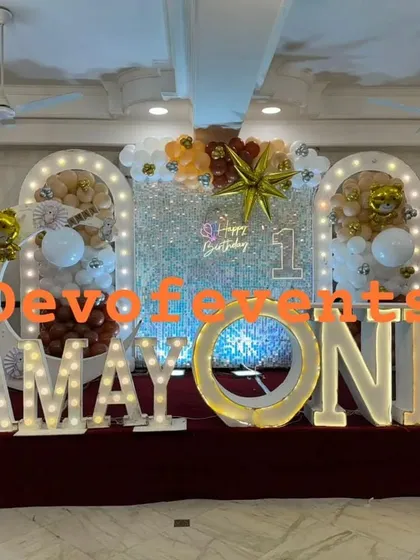 A complete stage setup for a teddy bear themed first birthday. I combined a full sequin shimmer wall with large marquee letters spelling "AMAY ONE", balloon arches, and cute teddy bear details for a grand and memorable celebration.