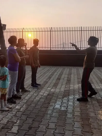 An instructor guiding students during a warm-up session at our Dadar range, with the sunset in the background.