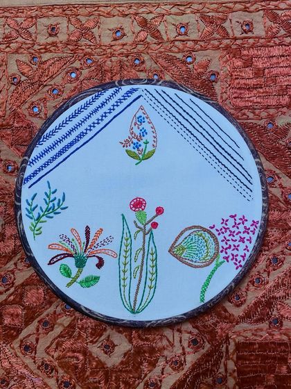 The finished freestyle embroidery hoop art, a captivating mix of floral motifs and abstract patterns. I can teach you how to create your own, or commission a custom piece.
