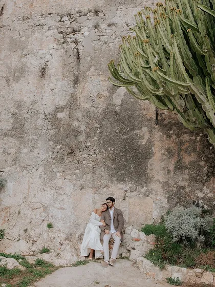 A quiet moment of togetherness for Brinda and Jeet, nestled against ancient stone walls and cacti on the French Riviera. This shot captures the rustic charm of the South of France.