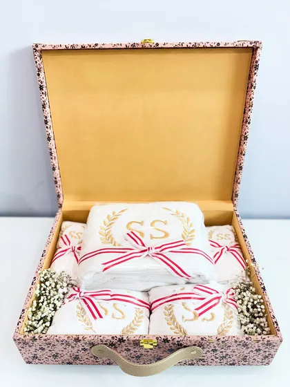 Inside the custom bride box, a set of towels embroidered with the couple's initials ("SS") is revealed.