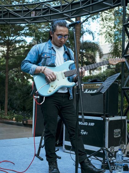 A close-up of a guitarist performing on stage at the World Food Carnival, showcasing the quality of live entertainment we bring to our events.