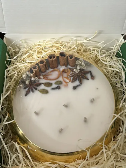 A close-up of our spice-topped urli candle in its gift box. The presentation is just as important as the candle itself.
