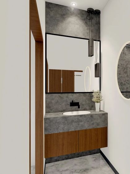A modern lavatory or powder room design. It features a concrete-finish countertop, a wooden vanity, and stylish pendant lighting for a chic, industrial look.
