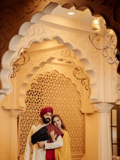 A beautifully framed shot of the couple under an ornate archway. The warm lighting and intricate details of the architecture add a touch of royal elegance to their portrait.