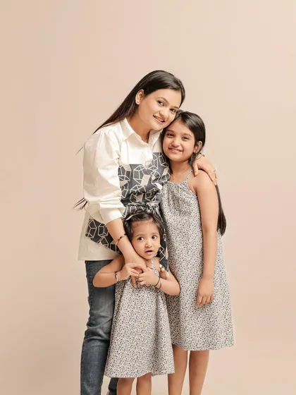 Three is not a crowd, it's a family. This portrait beautifully captures a mother with her two daughters, showcasing their close-knit bond.