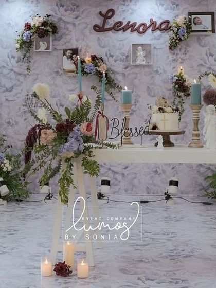 A full view of an offbeat baptism theme featuring ash grey blue and burgundy. The decor includes a beautiful floral arch, a vintage-style cradle, and personalized details.