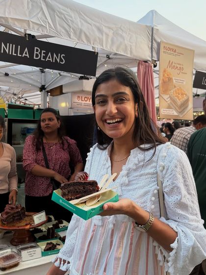 The smile says it all. A happy customer enjoying a slice of our cake at our stall. Seeing these moments is the best part of our job.