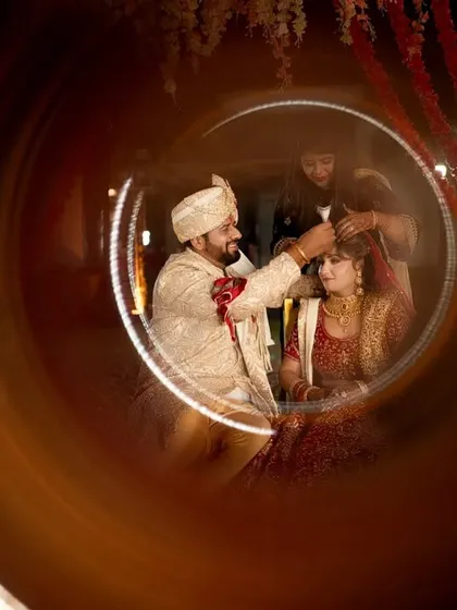 I love finding creative ways to frame sacred rituals. This shot, taken through a ring of light, focuses on a significant moment between the couple, turning a traditional ceremony into a unique and artistic memory.