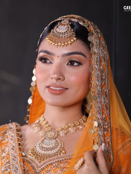 Student Work: This beautiful Punjabi bridal look features a warm, golden-hour glow with glossy lips and defined eyes, showcasing our students' ability to create diverse regional styles.