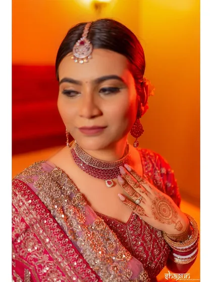 A close-up bridal portrait focusing on her stunning jewelry and the intricate details of her makeup and henna.