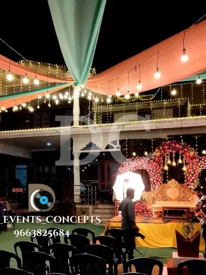 An outdoor Mehendi event at night, showcasing our venue draping and lighting. The colorful ceiling fabrics and string lights create a magical, tent-like atmosphere for the celebration.