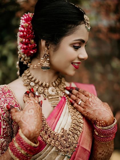 A close-up of a bride's joyful expression and her beautiful traditional jewelry.