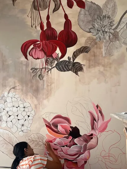 An earlier stage of the 'Native Grace' mural, showing the combination of fully painted red fuchsias and the delicate outlines of flowers yet to be colored.