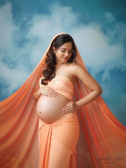A serene and contemplative pose amidst the clouds, with the orange fabric creating a beautiful halo effect.