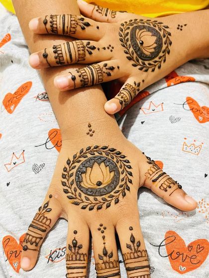 A matching set of lotus mandala designs for a child, with detailed finger bands.