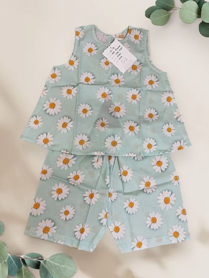 A flat lay of our adorable mint green sunflower co-ord set. It features a playful cut at the back and comfy cotton shorts, the ultimate blend of style and comfort.