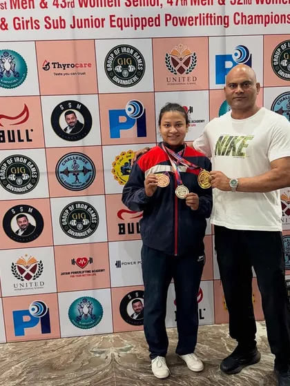 I don't just train lifters; I build champions. Here I am with my student Beena Parihar, celebrating her gold medals at the Junior National Powerlifting Championship. She set two national records, a testament to her hard work.