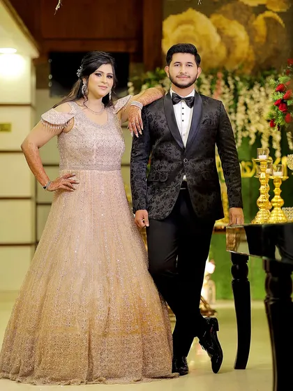 A stylish portrait of the couple at their engagement party. Their confident poses and coordinated outfits look fantastic against the elegant backdrop.