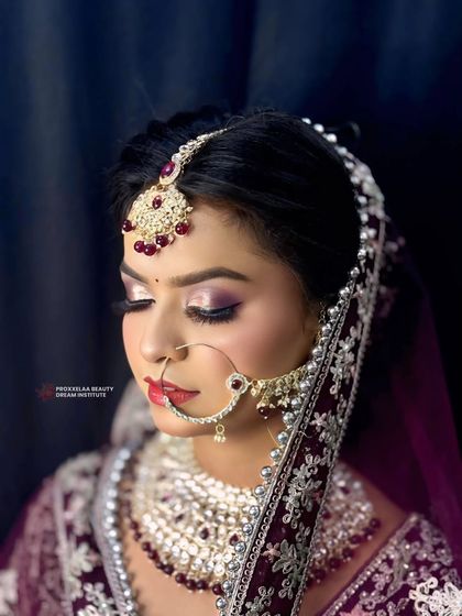 Eyes closed, the artistry shines through. This shot highlights the seamless eyeshadow blending and sharp winged liner that defines this royal bridal look.