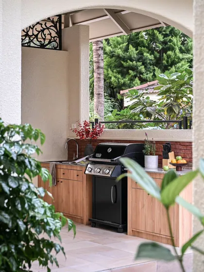 Your living space shouldn't end at the back door. I designed this covered outdoor kitchen to be a natural extension of the home, perfect for entertaining. It features durable wood-tone cabinetry, a granite countertop, and a high-end gas grill, creating a complete outdoor culinary experience.