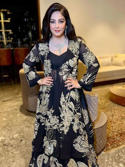 A full-length view of a client in a stunning black and gold outfit, with her hair in glamorous, voluminous waves. This hairstyle is designed to make a statement at any evening event.