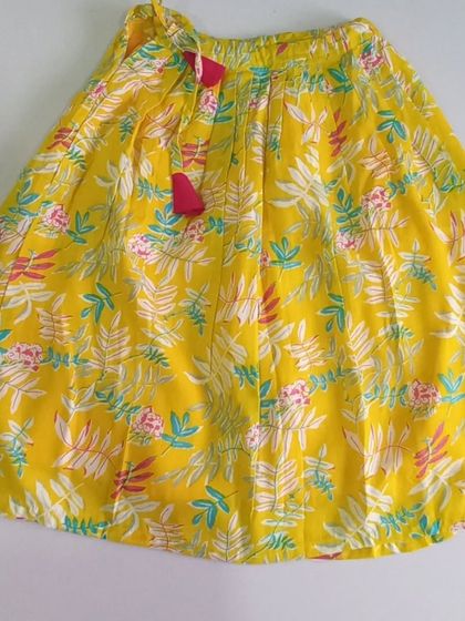 Here is the full skirt of the Meera Set. The bright yellow cotton is printed with a lovely floral design and includes a soft inner lining, plus a waist tie for easy adjustment.