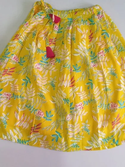 Here is the full skirt of the Meera Set. The bright yellow cotton is printed with a lovely floral design and includes a soft inner lining, plus a waist tie for easy adjustment.