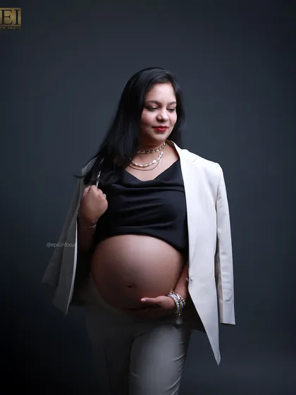 The modern "boss-mama" look. This studio portrait showcases a confident and stylish side of pregnancy, pairing a chic blazer with a bare bump for a powerful and contemporary statement.