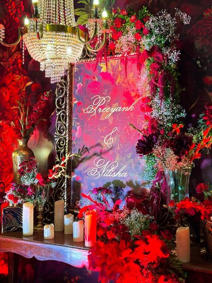 The personalized welcome sign for Preeyank and Nitisha, beautifully integrated into a lush floral wall. The elegant calligraphy and surrounding decor set a personal and high-end tone for the event.