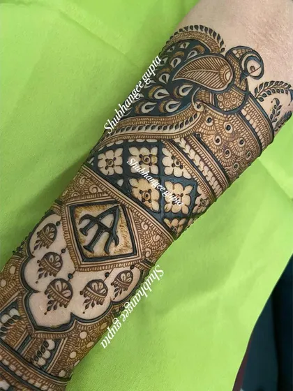 This engagement design includes the couple's initials 'A' and 'N' in a decorative diamond shape on the arm. It's a subtle but meaningful way to personalize your henna.