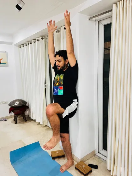 Using a wall for support in this standing balance pose helps cultivate mindfulness. It allows you to focus on your breath and the present moment without the added challenge of maintaining balance on your own.