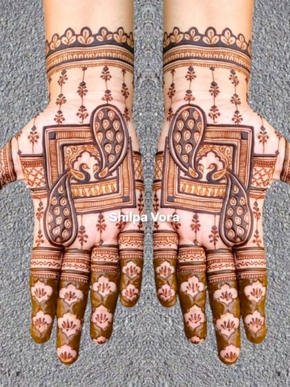 A unique design featuring peacocks inside a square frame, surrounded by delicate buti (small motifs).