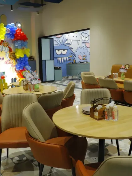 The dining area set up for a carnival-themed party. The bright backdrop is visible from the tables, creating a cohesive and festive atmosphere.