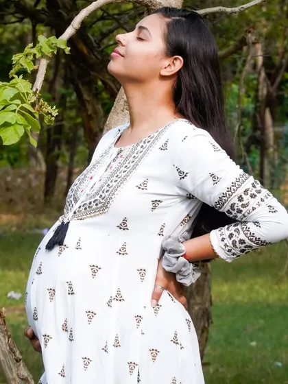 A beautiful side profile of an expecting mother enjoying the outdoors. We capture the beauty of pregnancy in natural, serene settings.