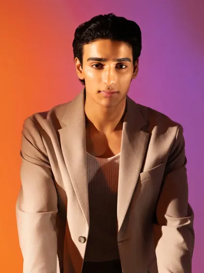 A direct, head-on portrait. The makeup is undetectable, simply enhancing his natural features for a camera-ready finish.