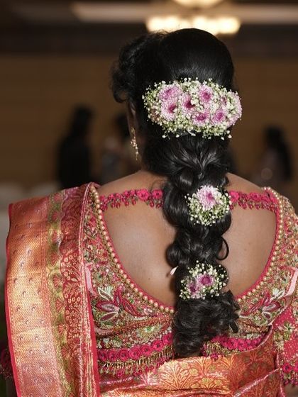 The back view of a bride's blouse, featuring an intricate cutout design bordered with delicate pearl and thread work. It’s a stunning detail that adds an element of surprise and sophistication.